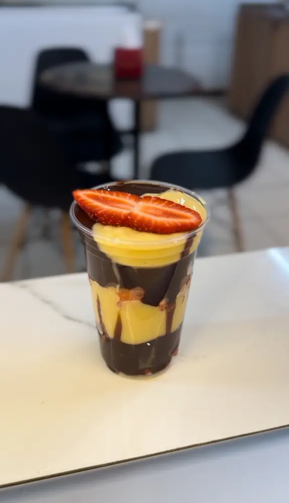 Copo de fondue em camadas de chocolate preto e branco com morango